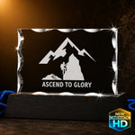 3D crystal notched rectangle engraved with a mountain climber and the text "Ascend to Glory" — corporate achievement award example on a black wood base